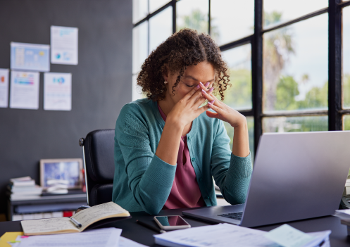 woman with head in hands at work